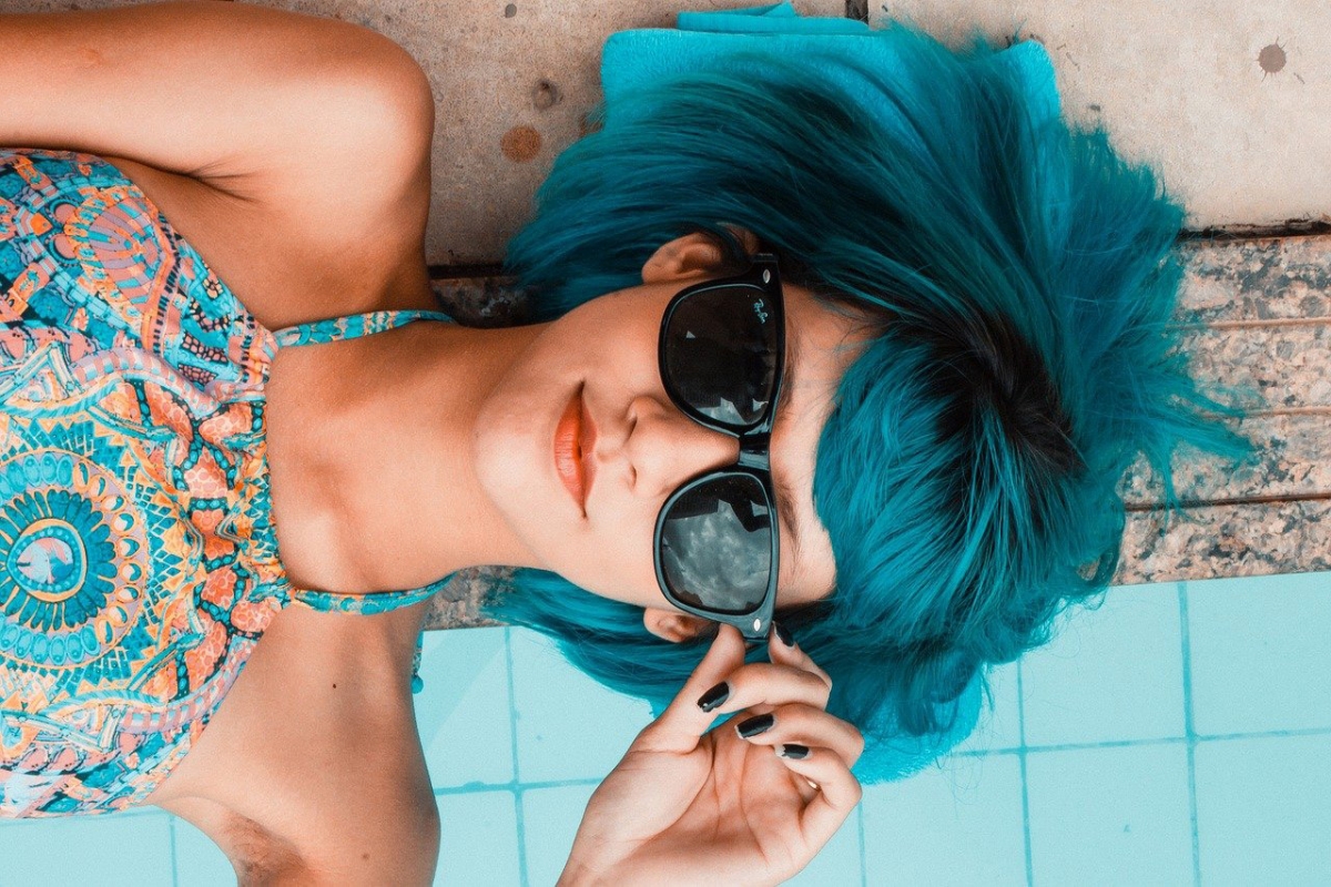 Frau mit blauen Haaren am Pool