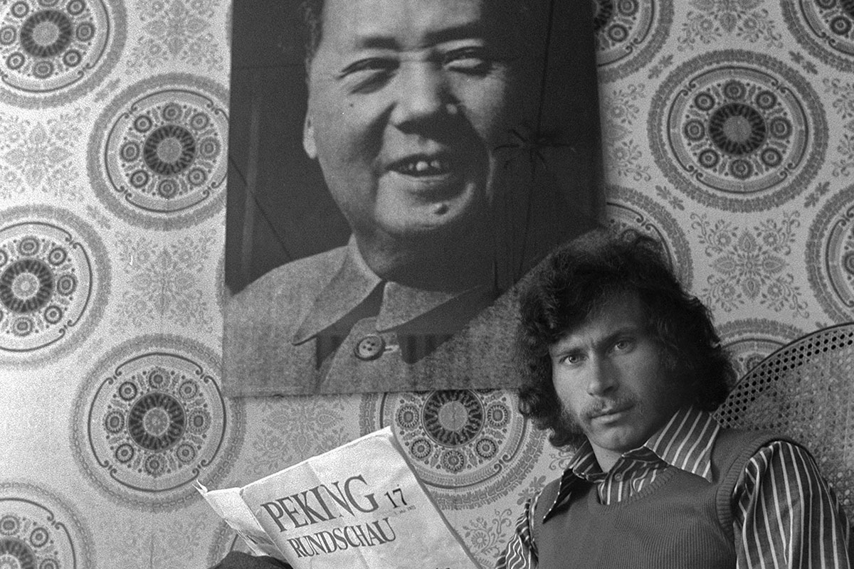 Paul Breitner mit Peking Rundschau vor Mao-Poster