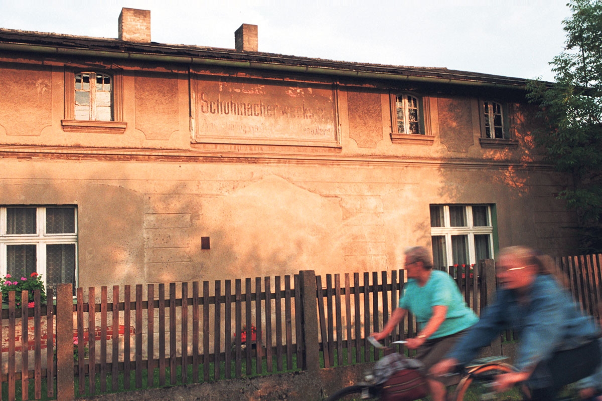 Verblichene deutsche Inschrift einer Schuhmacherwerkstatt an einer Hauswand aus der Zeit vor 1945 im oberschlesischen Jemielnica in Polen, aufgenommen am 2. August 1996