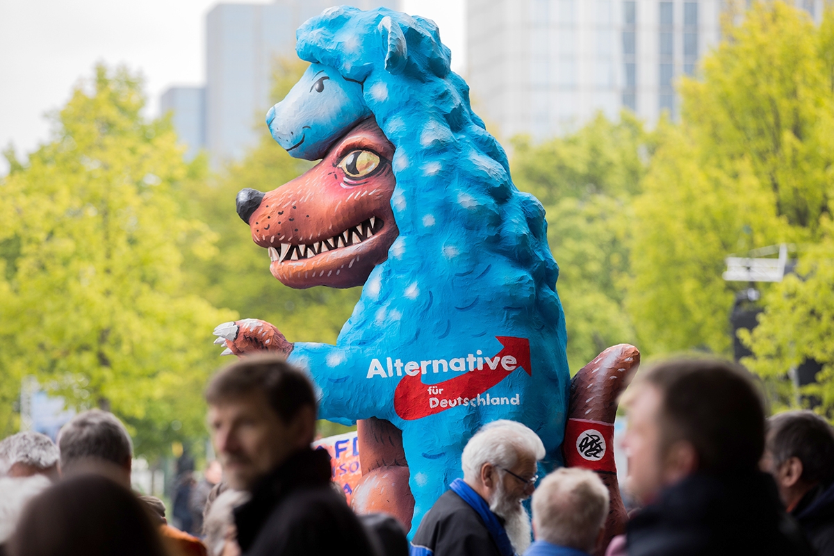 Eine von Karnevalswagenbau-Künstler Jacques Tilly entworfene Figur «Der Wolf im Schafspelz» steht am 28.04.2017 bei einem Wahlkampftermin der Alternative für Deutschland in Düsseldorf (Nordrhein-Westfalen) bei einer Gegendemonstration.