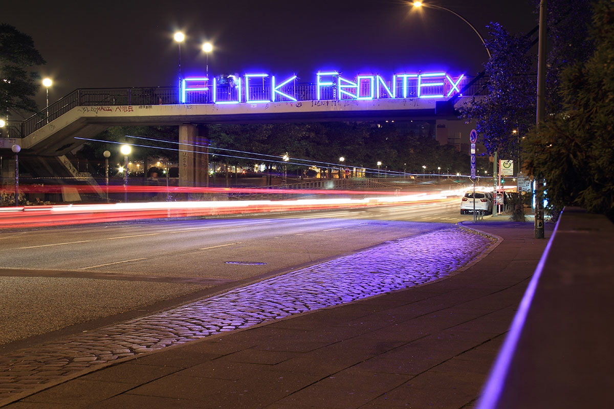 Neonschriftzug an einer Brücke: Fuck Frontex