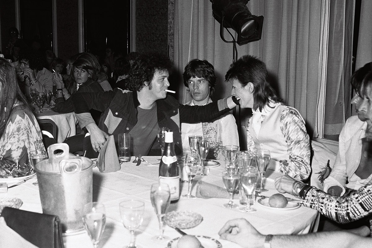 Reed und David Bowie bei einer Party in London, zwischen ihnen ein verdutzter Mick Jagger, 1973