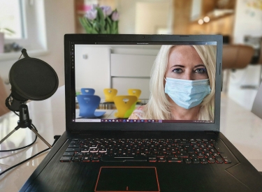 Homeschooling: eine Frau mit Maske ist auf einem Laptopbildschirm zu sehen