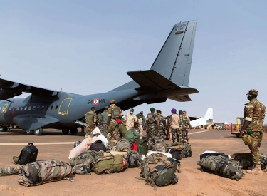 Soldaten mit Gepäck vor einem Flugzeug