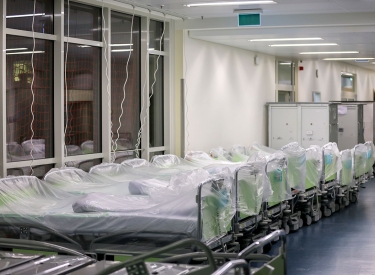 eine Reihe von unbenutzten Betten auf einem Krankenhausflur
