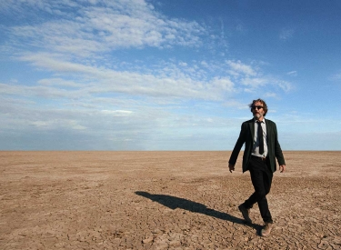 Ein Mann im Anzug geht durch die Wüste