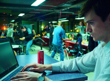 Filmbild: Ein Mann arbeitet an einem Laptop