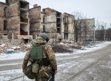 Ein Soldat vor einer ausgebombten Häuserreihe
