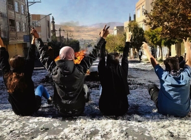 Frauen posieren an einer brennenden Barrikade