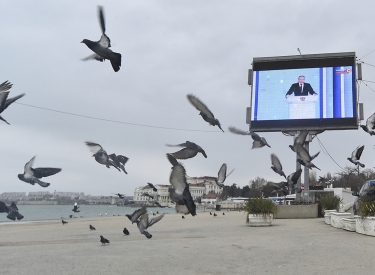 Putins Rede wird auf einem Bildschirm am Hafen übertragen