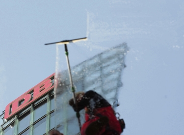 Eine Reinigungskraft säubert eine Glasfassade am Potsdamer Platz, 2009