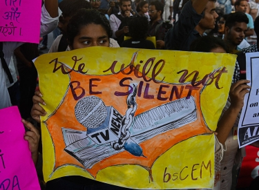 Demonstrantin mit Plakat »We will not be silent«