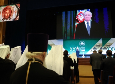 Patriarch Kyrill (auf der Bühne) und der zugeschaltete russische Präsident Wladimir Putin bei der Plenarsitzung der Volkssynode im Kremlpalast, 28. November