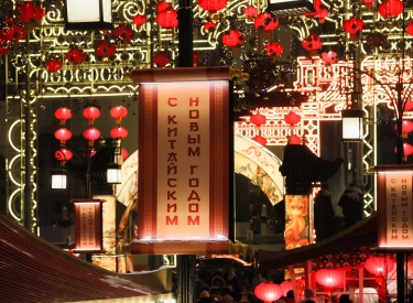 Festlich rot dekorierte Innenstadt. Ein Schild mit der Aufschrift »Frohes Chinesisches Neujahr« in der Moskauer Kamergerskij-Gasse, 9. Februar